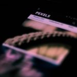 Smartphone em close com imagens e textos desfocados na tela, remetendo a uma interface de rede social.