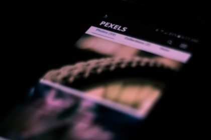 Smartphone em close com imagens e textos desfocados na tela, remetendo a uma interface de rede social.